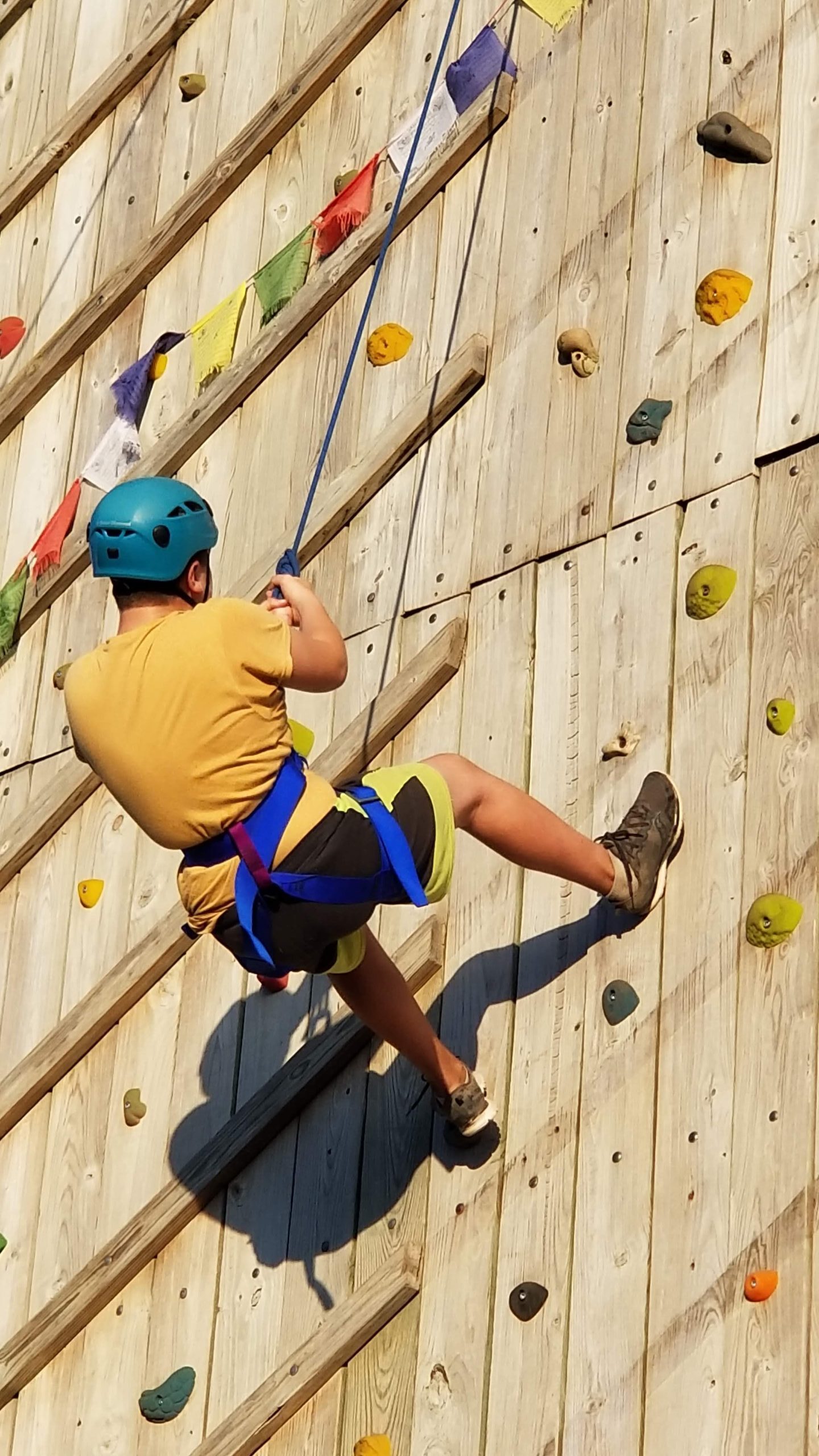 Scout scaling the outdoor climbing wall at Camp Hohn