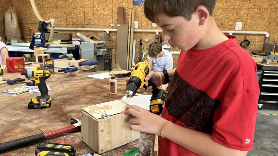 Scout building a project with power tools in the Program Building woodworking shop